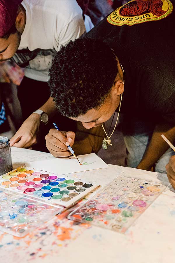 a young man bent over a table painting